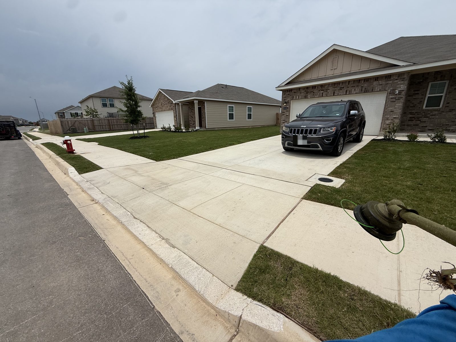 Gonzales Landscaping truck and trimmer in the driveway of a freshly mowed lawn