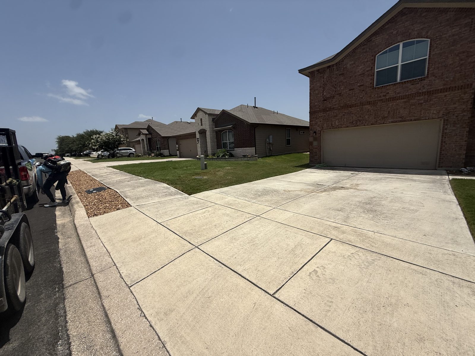 Gonzales Landscaping crew member with equipment arriving for a lawn mowing job