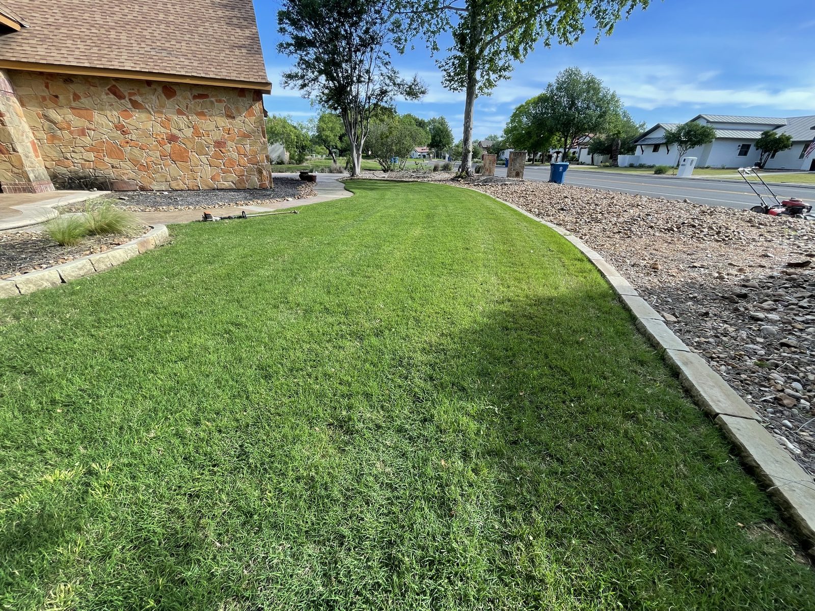 Freshly mowed and edged lawn along a stone walkway in Cibolo, TX by Gonzales Landscaping
